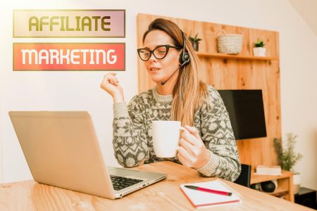 Młoda kobieta używająca telefonu kom&oacute;rkowego na stole