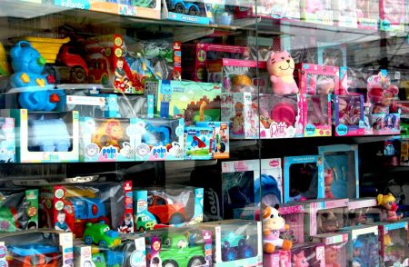Toys are displayed inside of a store window.