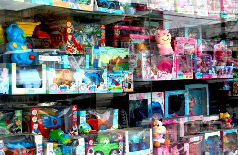 Toys are displayed inside of a store window.