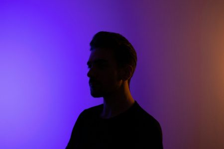 a man standing in front of a purple wall