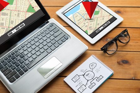nawigacja, responsywny projekt i koncepcja technologiczna - zbliżenie na laptopie, tablecie, notebooku i okularach z mapą nawigatora gps i schematem na drewnianym stole
