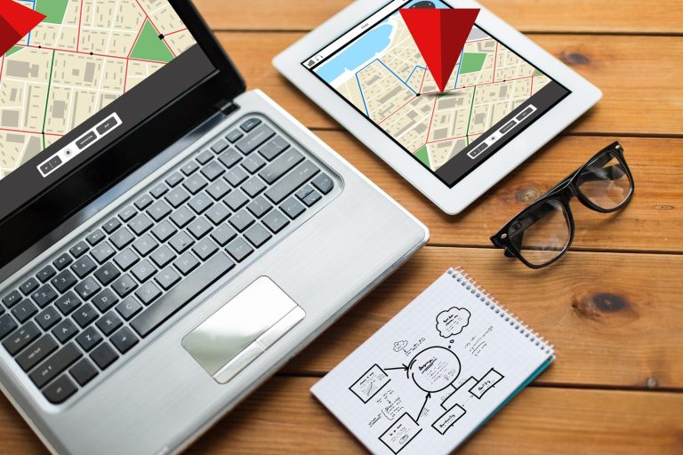 nawigacja, responsywny projekt i koncepcja technologiczna - zbliżenie na laptopie, tablecie, notebooku i okularach z mapą nawigatora gps i schematem na drewnianym stole