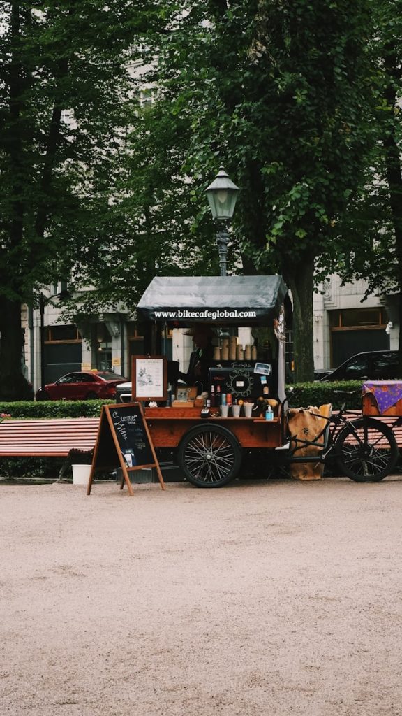 Mobilna kawiarnia na rowerze lub w przyczepie – koszty i zarobki brown wooden carriage in front of brown wooden house during daytime