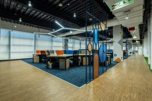 CRM w małej firmie: inwestycja czy zbędny wydatek? an office with a wooden floor and blue and orange chairs