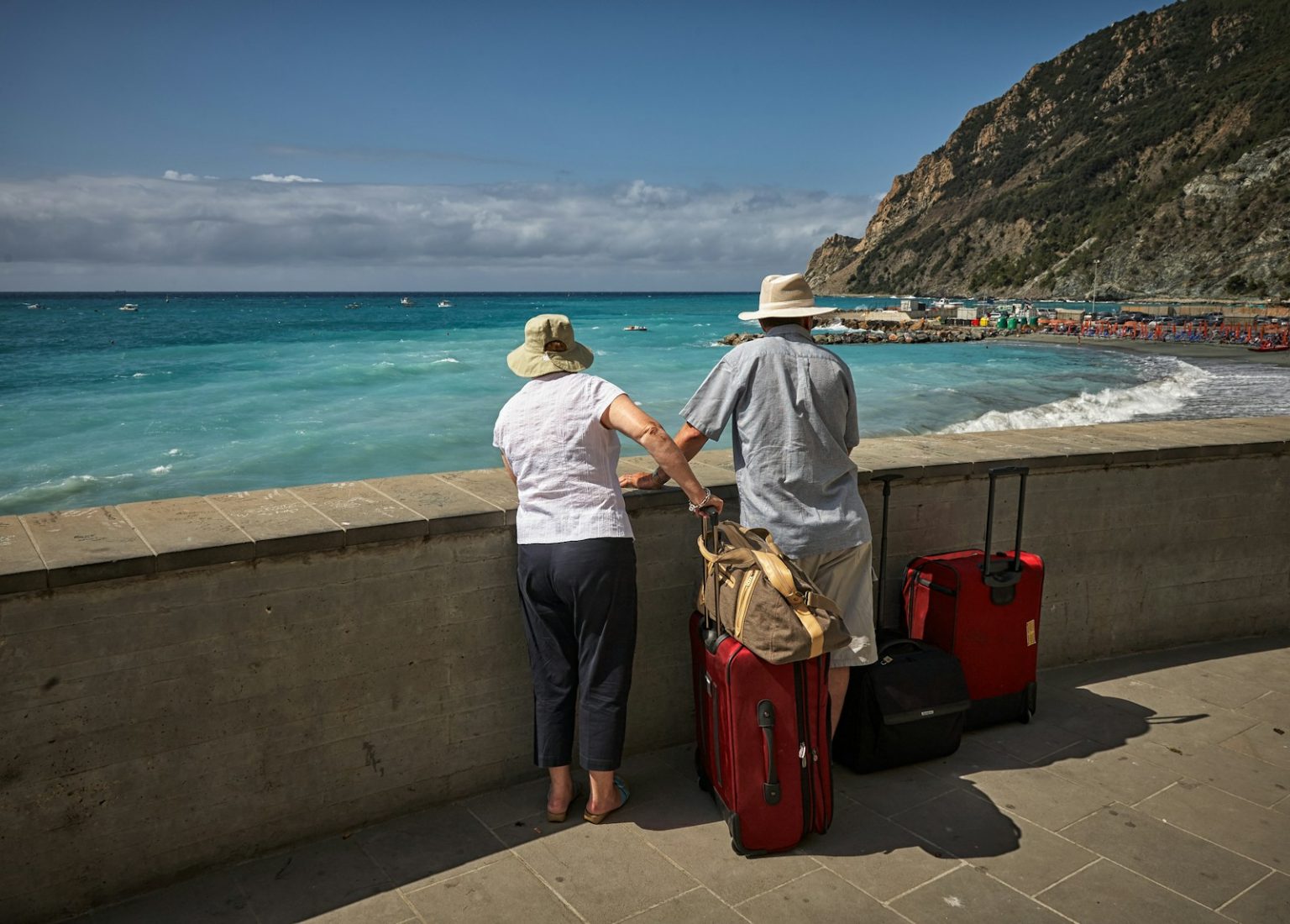 Franczyza biura podróży – jakie są zarobki i prowizje? Przegląd ofert man and woman standing beside concrete seawall looking at beach