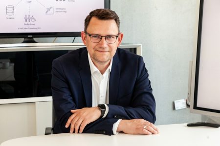 Gwarancja na firmę: rok czy dwa? Jak faktura VAT i sprzedaż B2B wpływają na okres gwarancyjny? Man in suit and glasses sits at table