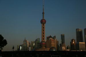A tall building with a red top in a city