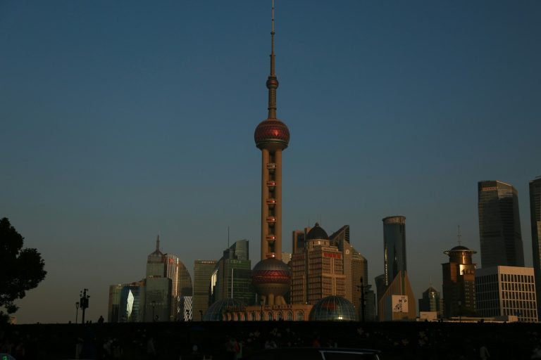A tall building with a red top in a city