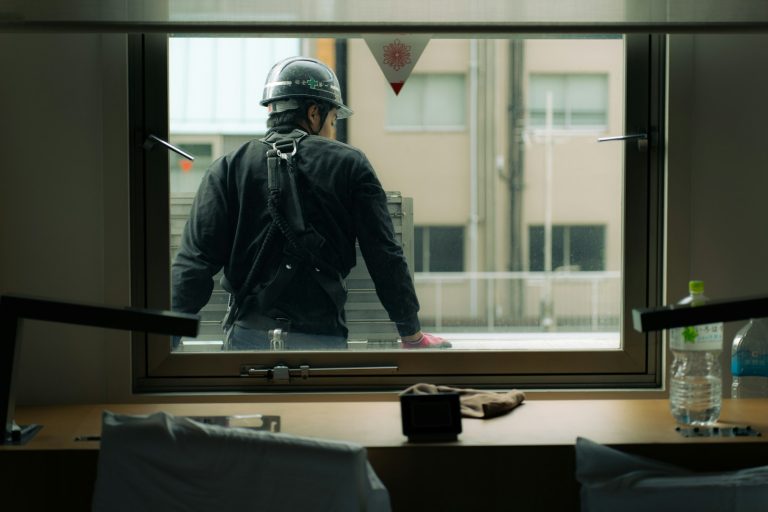 A construction worker looks out the window.